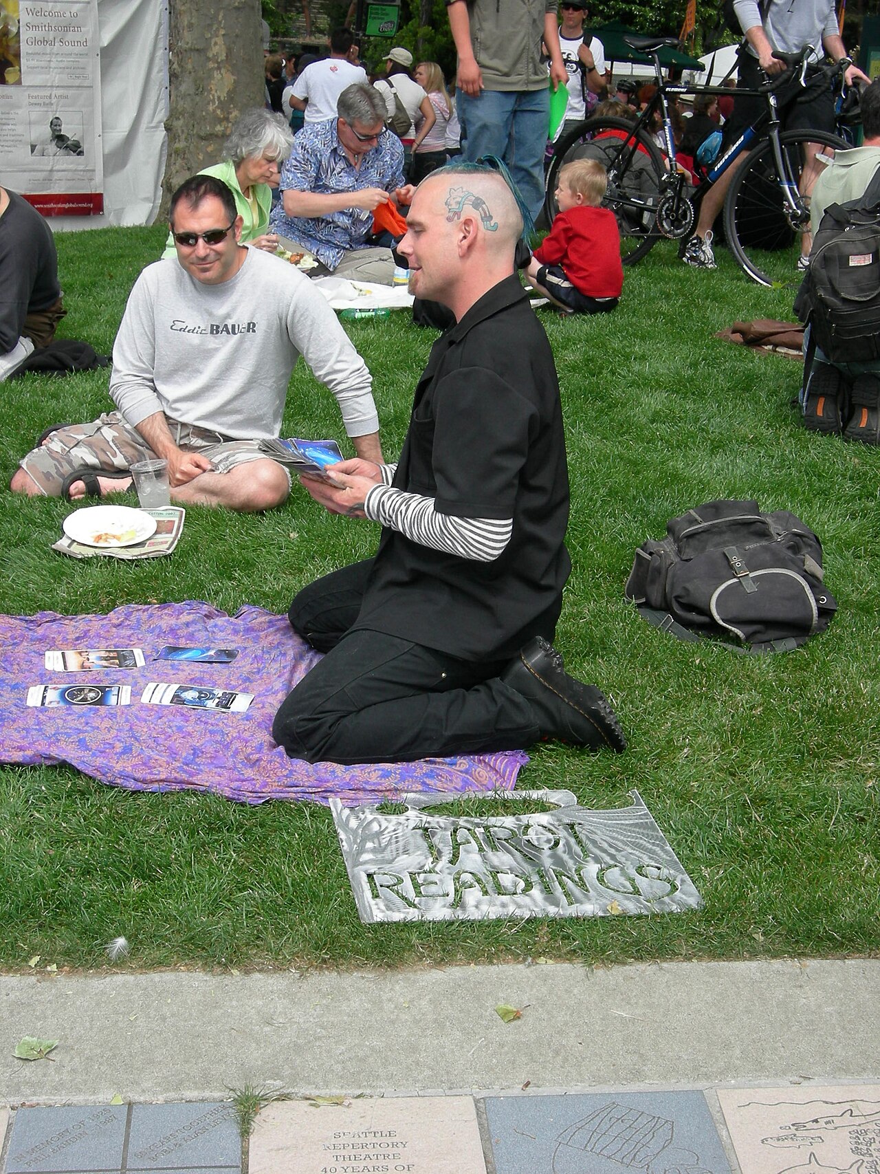 Professional tarot reader consulting cards at a public table
