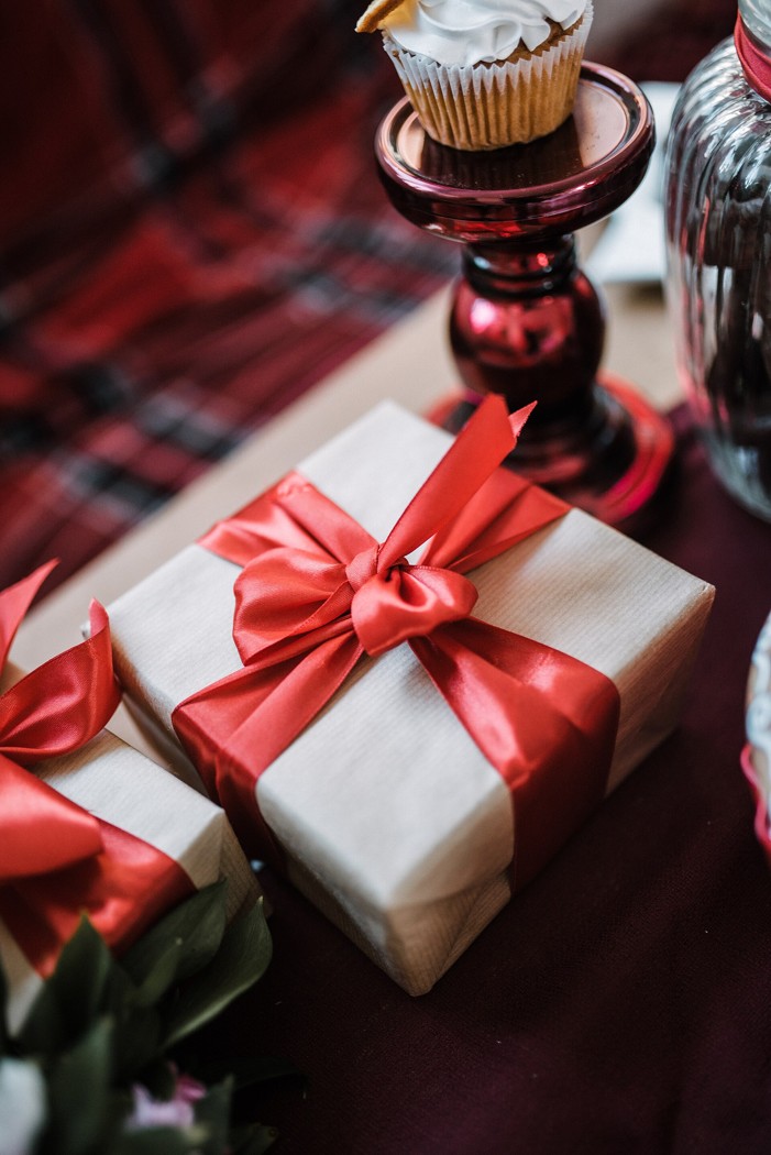 A brown gift box tied with a red ribbon and bow