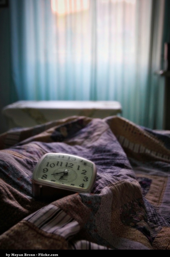 Alarm clock resting on a bed in morning light