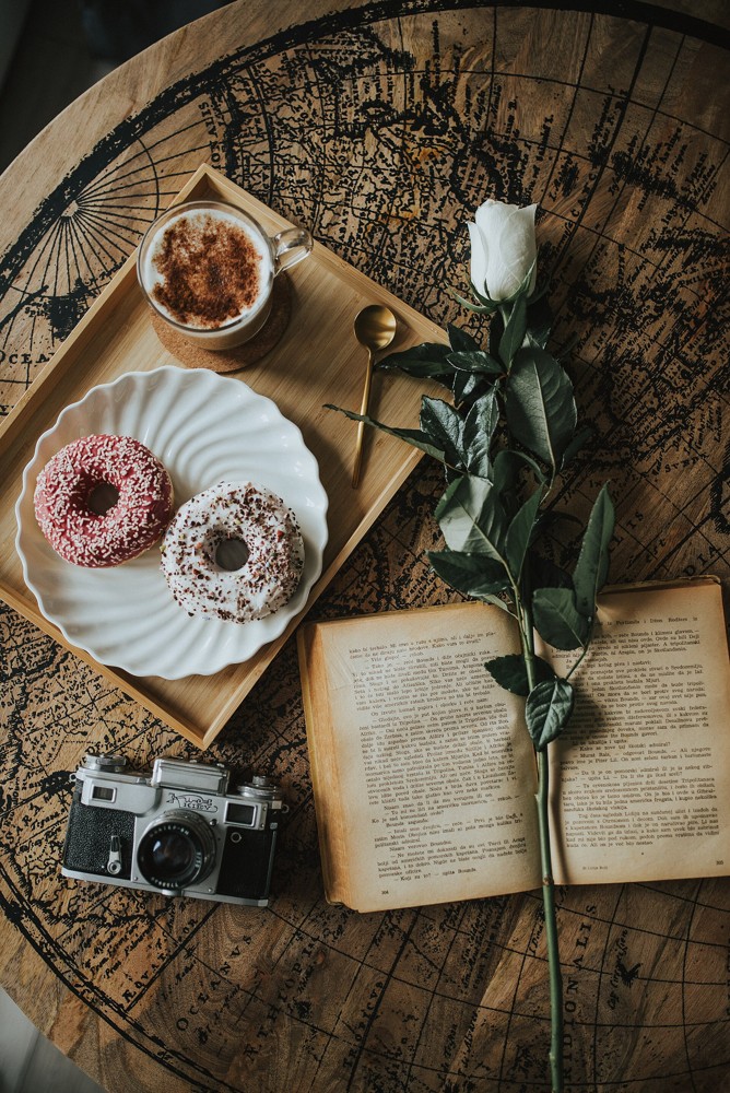 A camera, book and refreshments arranged on a table