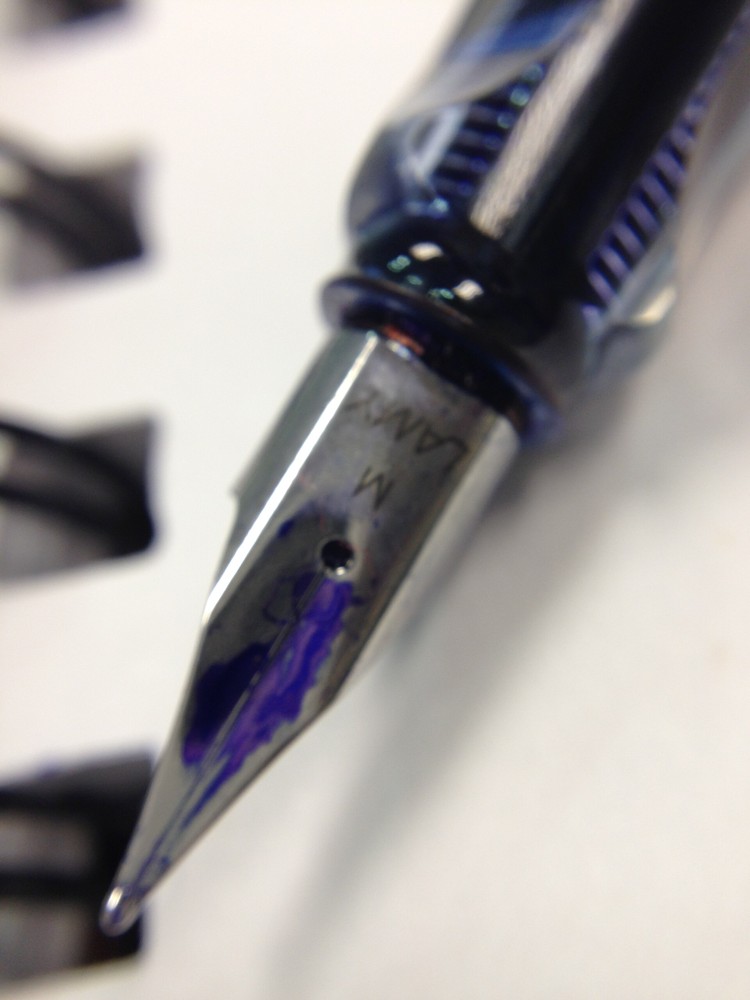 Close-up of a fountain pen resting beside handwritten notes